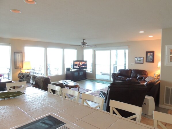 A spacious living room with a large TV, comfortable seating, and a dining area.