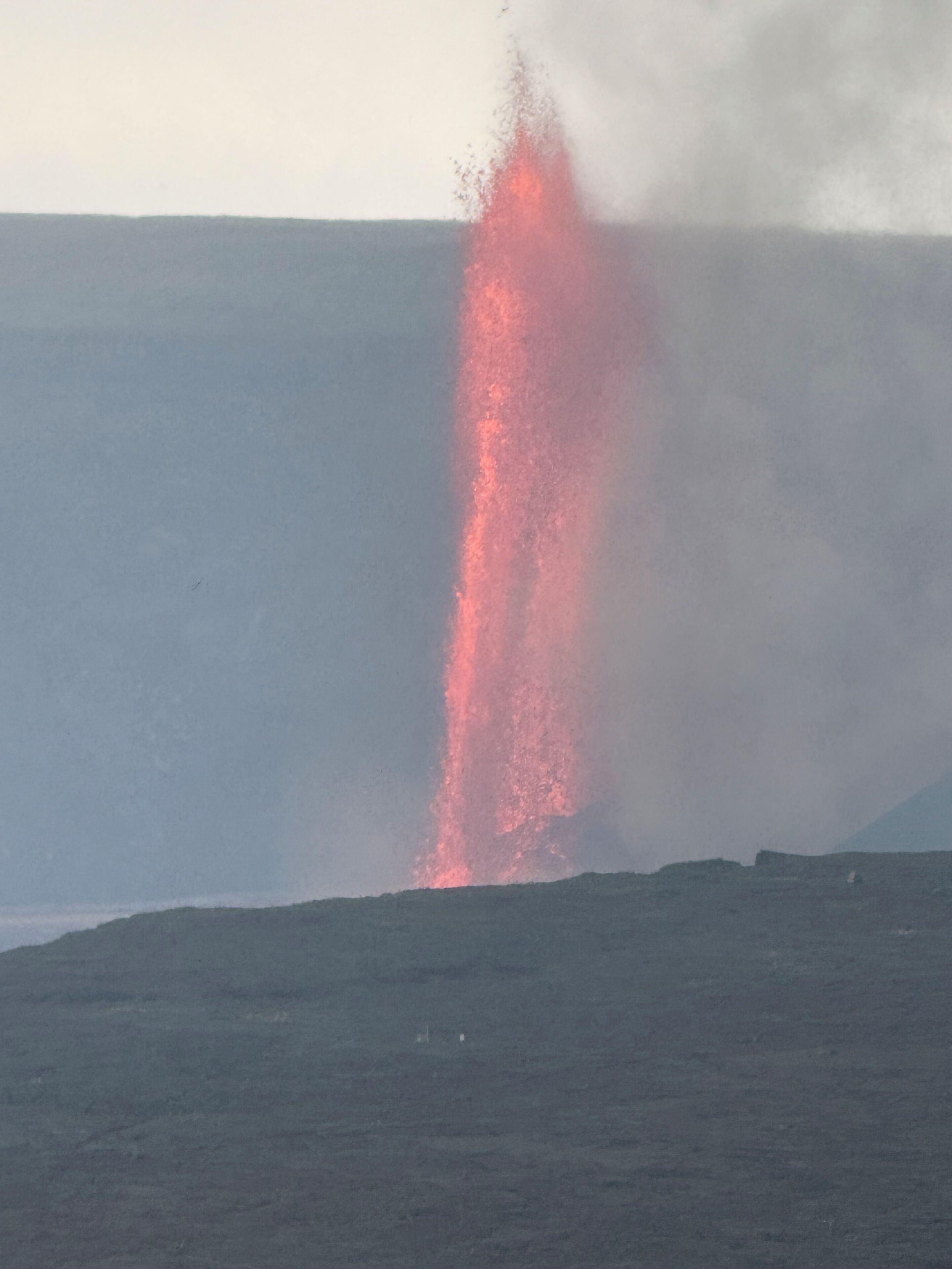 A volcanic eruption with lava flowing down a slope.