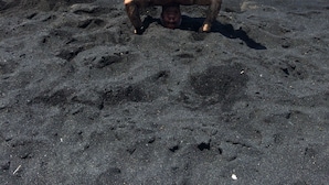 A person performing a handstand on a black sand beach with ocean in the background. - Cozy House near the Hawaii Volcanoes National Park & Volcano Village on 1.5 Acre (Volcano)