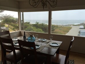 A dining area with a table set for two, overlooking a coastal view. - On the water in Pacific Grove (Pacific Grove)
