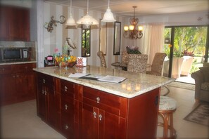 Enjoy cooking in the well-appointed kitchen with a large island, microwave, and refrigerator.