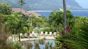 A resort with a pool, lounge chairs, and a view of the ocean and mountains. - HanaleiBayRESORT 2311, 169.00 BlowOutSale Oct Open Days BeachFront 10 Stars!! (Princeville)