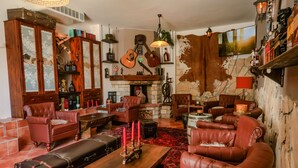 A cozy living room with leather furniture, a fireplace, and a mounted guitar. - Deluxe suite in the middle of Plitvice lakes (Plitvice lakes)