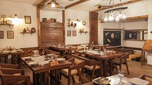 A restaurant with wooden tables and chairs, equipped with wine glasses and plates. - Deluxe suite in the middle of Plitvice lakes (Plitvice lakes)