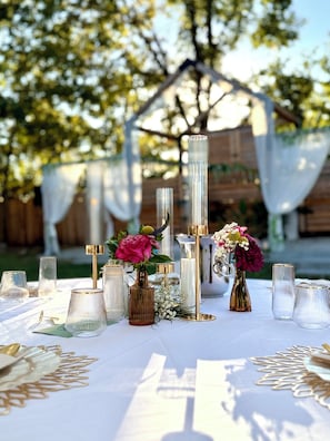 Ein Tisch, reich gedeckt mit klarem Glas, goldenen Akzenten und Blumenarrangements.