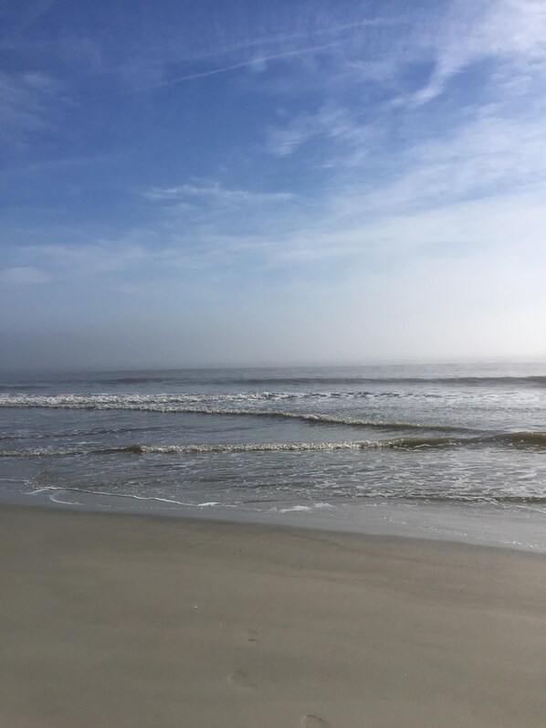 Uma praia com ondas e céu claro.
