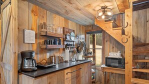 A rustic kitchen with wooden walls, a coffee maker, a microwave, and various kitchen utensils. - Quiet, Comfy Black Hills Cabin; Within 10 Mi of Mt. Rushmore & Custer State Park (Keystone)