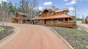 A rustic lodge with a prominent wooden structure, a gravel driveway, and a clear sky. - Quiet, Comfy Black Hills Cabin; Within 10 Mi of Mt. Rushmore & Custer State Park (Keystone)