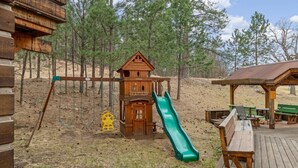 A wooden play structure with a slide, swings, and a small house labeled '3-10 years old.' - Quiet, Comfy Black Hills Cabin; Within 10 Mi of Mt. Rushmore & Custer State Park (Keystone)