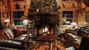 A cozy log cabin interior with a stone fireplace, leather sofas, and a moose head decoration. -  Spring /Summer availability!  On 2 creeks, wood burning fireplc, log gazebo. (Rhododendron)