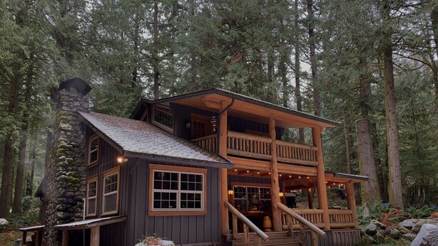 A rustic cabin with a stone chimney, wooden balconies, and a porch with steps leading to a deck. -  Spring /Summer availability!  On 2 creeks, wood burning fireplc, log gazebo. (Rhododendron)