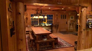 A wooden interior with a central dining table, benches, and a chandelier. -  Spring /Summer availability!  On 2 creeks, wood burning fireplc, log gazebo. (Rhododendron)