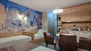 Tunnelmallinen huone, jossa on sänky, työpöytä ja tuoli sek ä seinällä talviteemainen seinämaalaus.