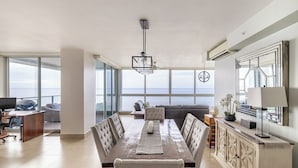 A spacious dining area with a large table, chairs, and a view of the ocean. - Rio Mar Premier Beachfront Community - Beach-Pools-Spas-Surf-Mountains (Riomar)