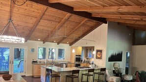 A spacious kitchen with a central island, wooden ceiling beams, and large windows. - A Family Retreat Among the Redwoods. (Cazadero)