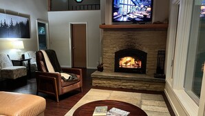 A cozy living room with a fireplace, a television, and comfortable seating. - A Family Retreat Among the Redwoods. (Cazadero)
