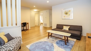 A living room with a sofa, a coffee table, a patterned couch, and a rug.