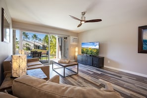 Relax in this stylish living room with a large flat-screen TV, dining area, and comfortable seating options.