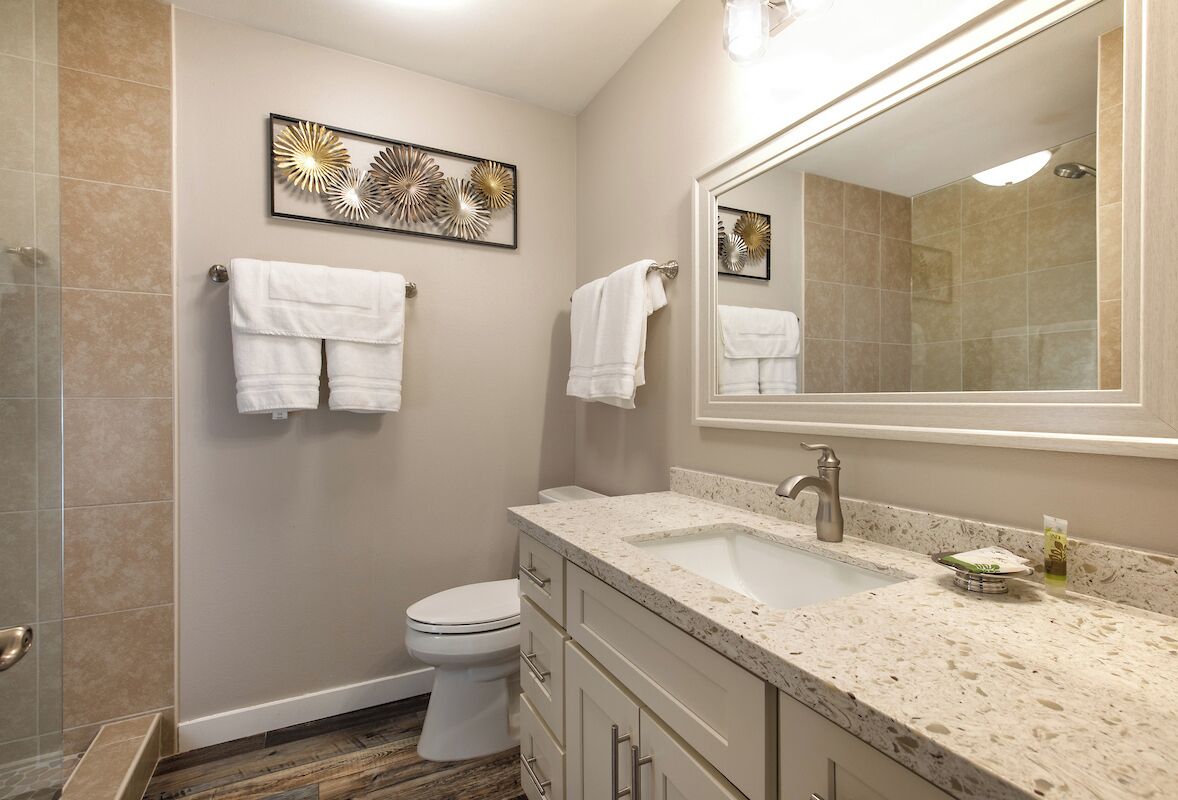 A modern bathroom with a sink, mirror, and toilet.
