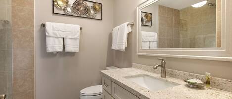 A modern bathroom with a sink, mirror, and toilet.