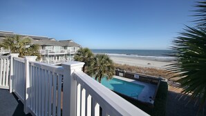 A balcony with a view of a beach and a swimming pool. - OCEANFRONT TH with pool on the beach! (Surfside Beach)