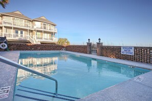 Enjoy a refreshing swim in the pool surrounded by a low wall and metal handrail.