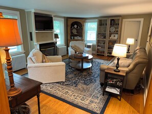 A living room with a fireplace, a television, and a bookshelf.