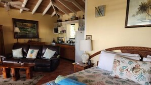 Een gezellige kamer met een bed, een bank en een eethoek.