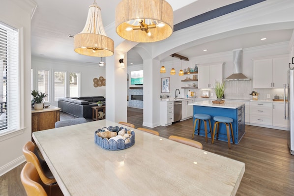 A spacious kitchen with white cabinets, a central island with stools, and pendant lighting. - ⭐ Top Shelf - The Nicest Pool in all Destiny! Private, Elevated, 5 Star! (Destin)
