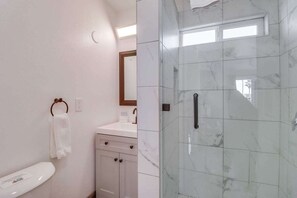 Een bad/douchecombinatie, een haardroger, handdoeken, shampoo
