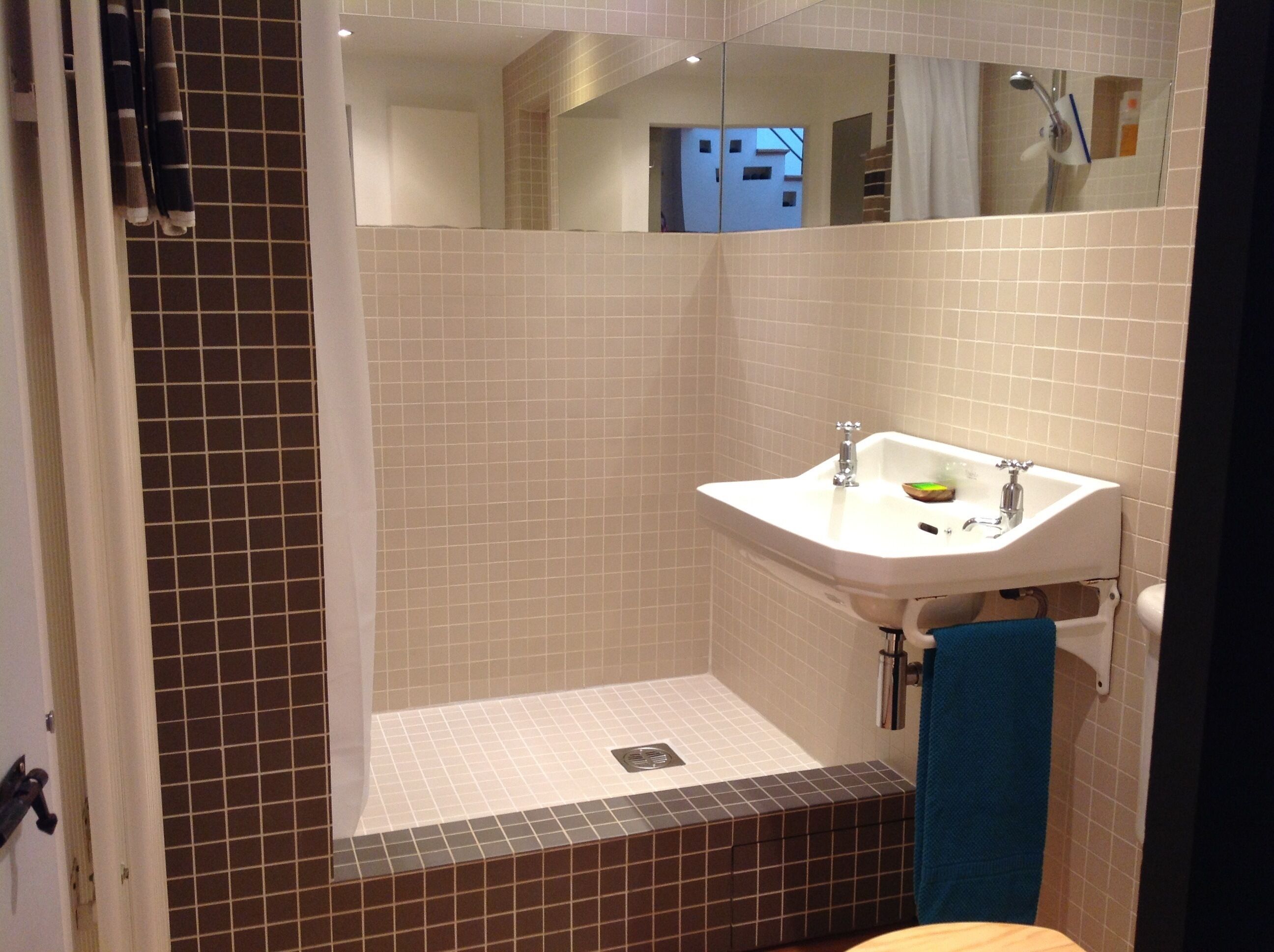 A bathroom with a white sink, a mirror, and a shower area.