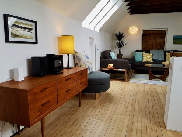 Una sala de estar moderna con un mueble de madera, un juego de sofá, una mesa de centro y una lámpara.