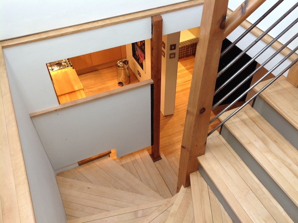 Eine Holztreppe mit Blick auf eine darunterliegende Küchenzeile.