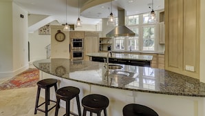 A spacious kitchen with a large island, stainless steel appliances, and pendant lighting. - 6 Piping Plover-A true smart home with media room! 146 Yard walk to the Beach (Hilton Head Island)