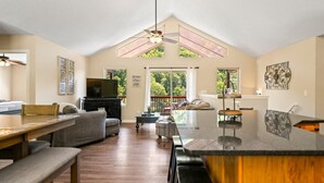 A spacious living room with a high ceiling, a dining area, and a kitchen with a large island. - Beautiful Lakefront Getaway - Sleeps 26 - Norris Lake’s Best Location (La Follette)