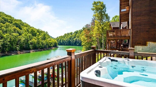 A wooden building with a balcony overlooking a river and forest. - Beautiful Lakefront Getaway - Sleeps 26 - Norris Lake’s Best Location (La Follette)