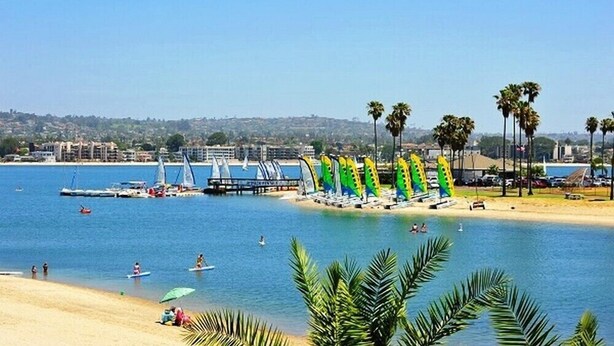 A beach with palm trees, a marina, and sailboats. - Paradise Retreat | 2BR Bayfront w/ Spacious Patio (San Diego)