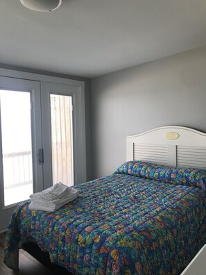 A bedroom with a bed, a window, and a door. - Affordable Oceanfront w/ Private Pool! (Emerald Isle)