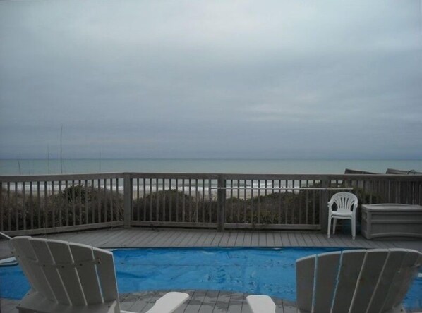 A wooden deck with a pool, beach chairs, and a view of the ocean. - Affordable Oceanfront w/ Private Pool! (Emerald Isle)