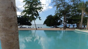 Ein Poolbereich mit Blick auf Strand und Meer.