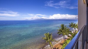 Un balcon avec vue sur une plage et l’océan.