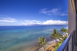Uma varanda com vista para a praia e o oceano.
