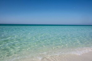 A clear view of a beach with shallow water and a sandy shore. - Leeward Key 603 Beach Service included Newly renovated (Miramar Beach)