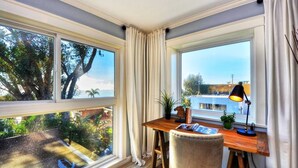 A room with a desk, chair, and two windows with curtains. - Villa Laguna -- ocean views, walkable, and new (Laguna Beach)