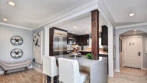 A modern kitchen with a central island, stainless steel appliances, and a bench by the wall. - Villa Laguna -- ocean views, walkable, and new (Laguna Beach)