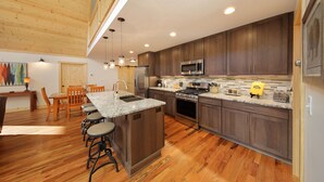 Una cocina moderna con armarios de madera, electrodomésticos de acero inoxidable y encimera de granito.