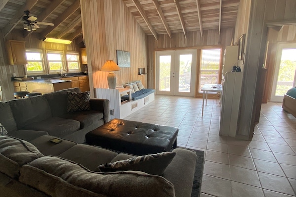 Open living area with kitchen and French doors onto the back deck