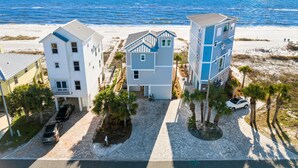 Une propriété située en bord de mer, avec des bâtiments de trois étages, un espace de stationnement et une vue sur l’océan.