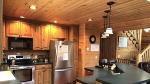A kitchen with wooden cabinets, stainless steel appliances, and a central island.