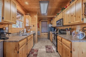 Una cocina compacta con armarios de madera, microondas integrado y cafetera.